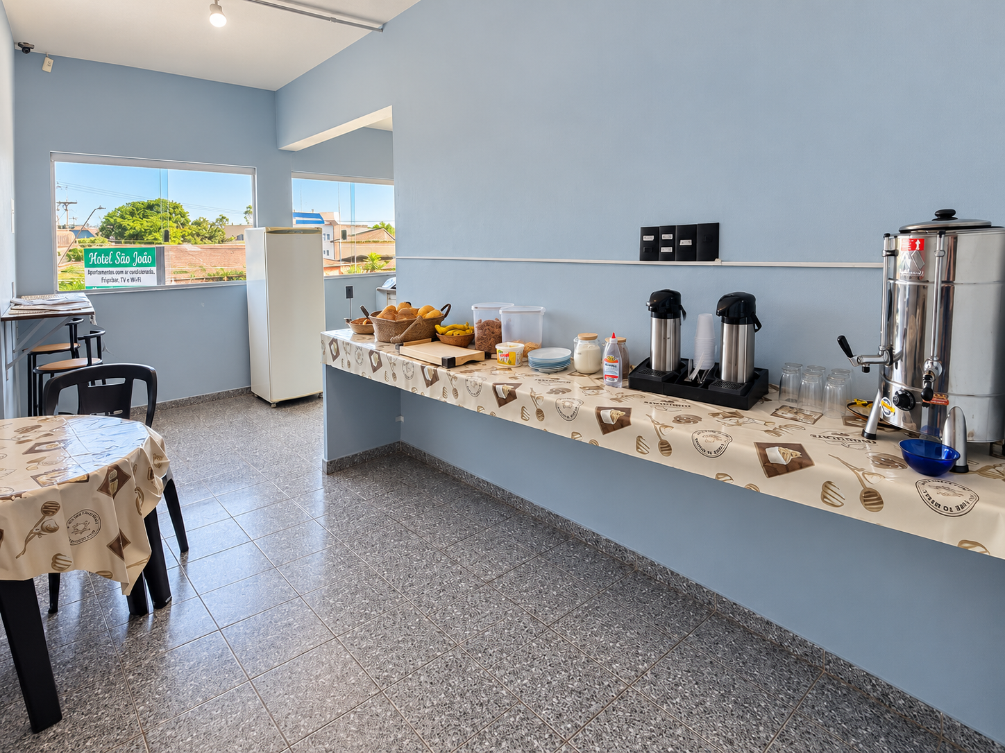 Salão de café da manhã do Hotel São João, com mesas e balcão de buffet